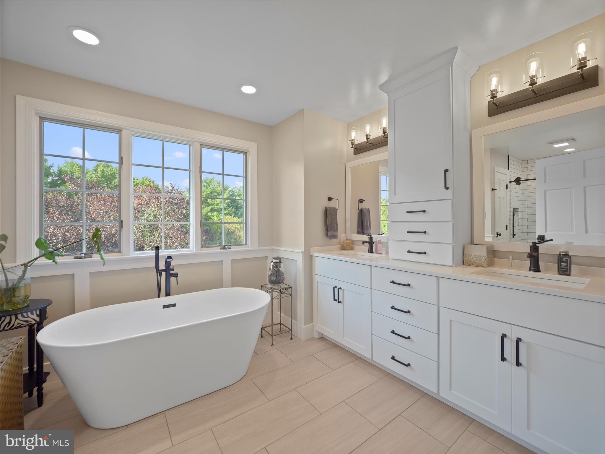 10306 Church Hill Road Myersville, MD 21773 - Photo 20 of 81 a spacious bathroom with a double vanity sink a mirror and a large window
