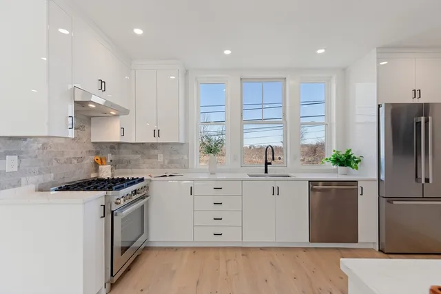 a kitchen with white cabinets and stainless steel appliances