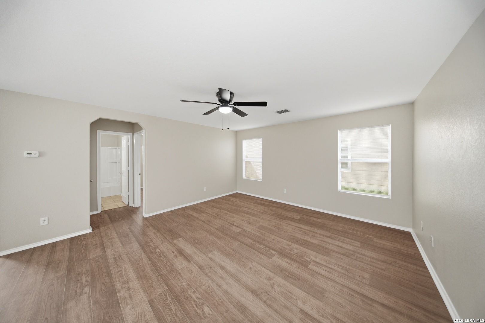 403 Walnut Crest Schertz, TX 78154 - Photo 8 of 30 an empty room with wooden floor ceiling fan and windows