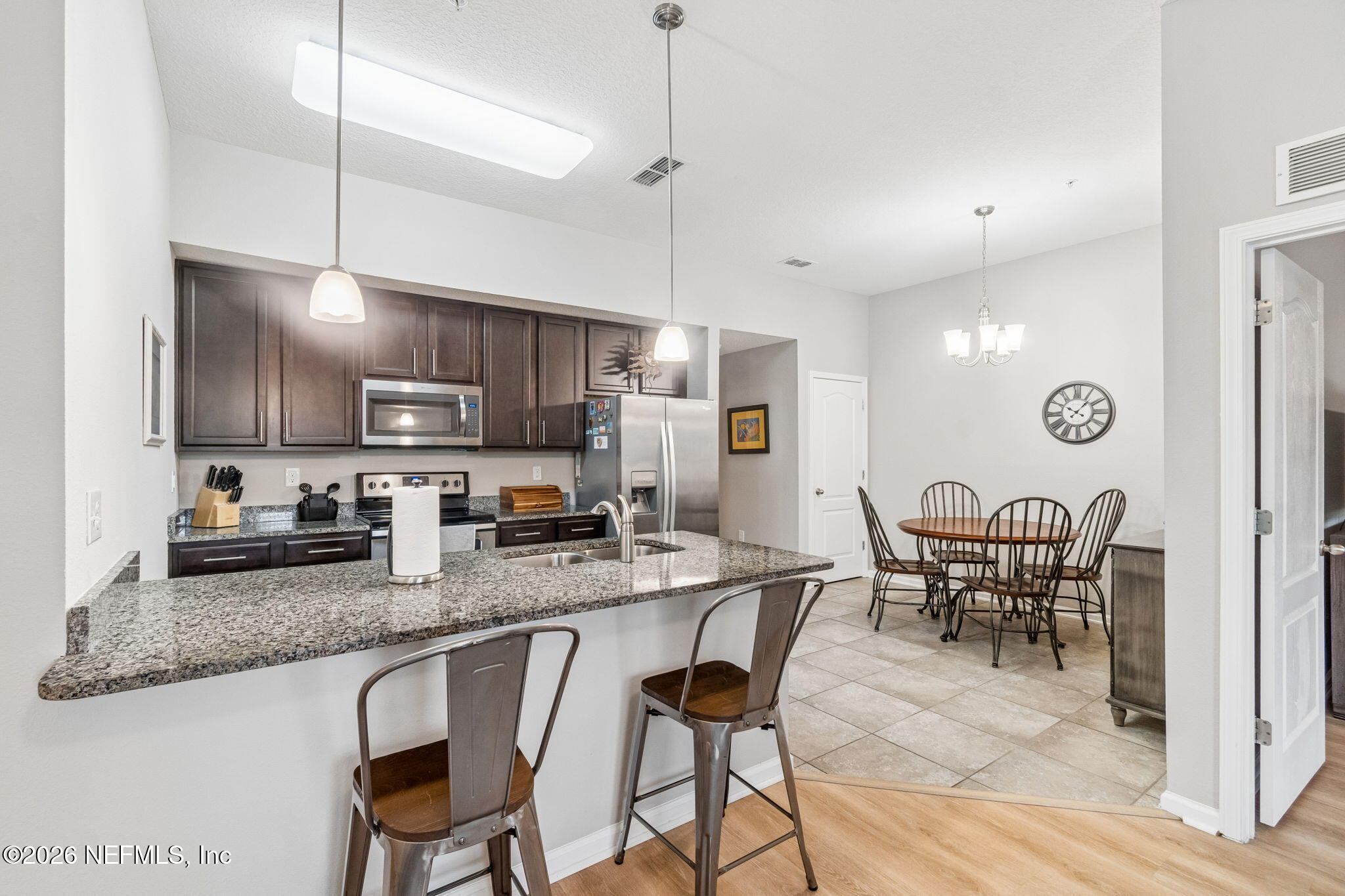 2113 Golden Lake Loop St. Augustine, FL 32084 - Photo 16 of 50 a kitchen with stainless steel appliances granite countertop a stove top oven a refrigerator a sink and chairs
