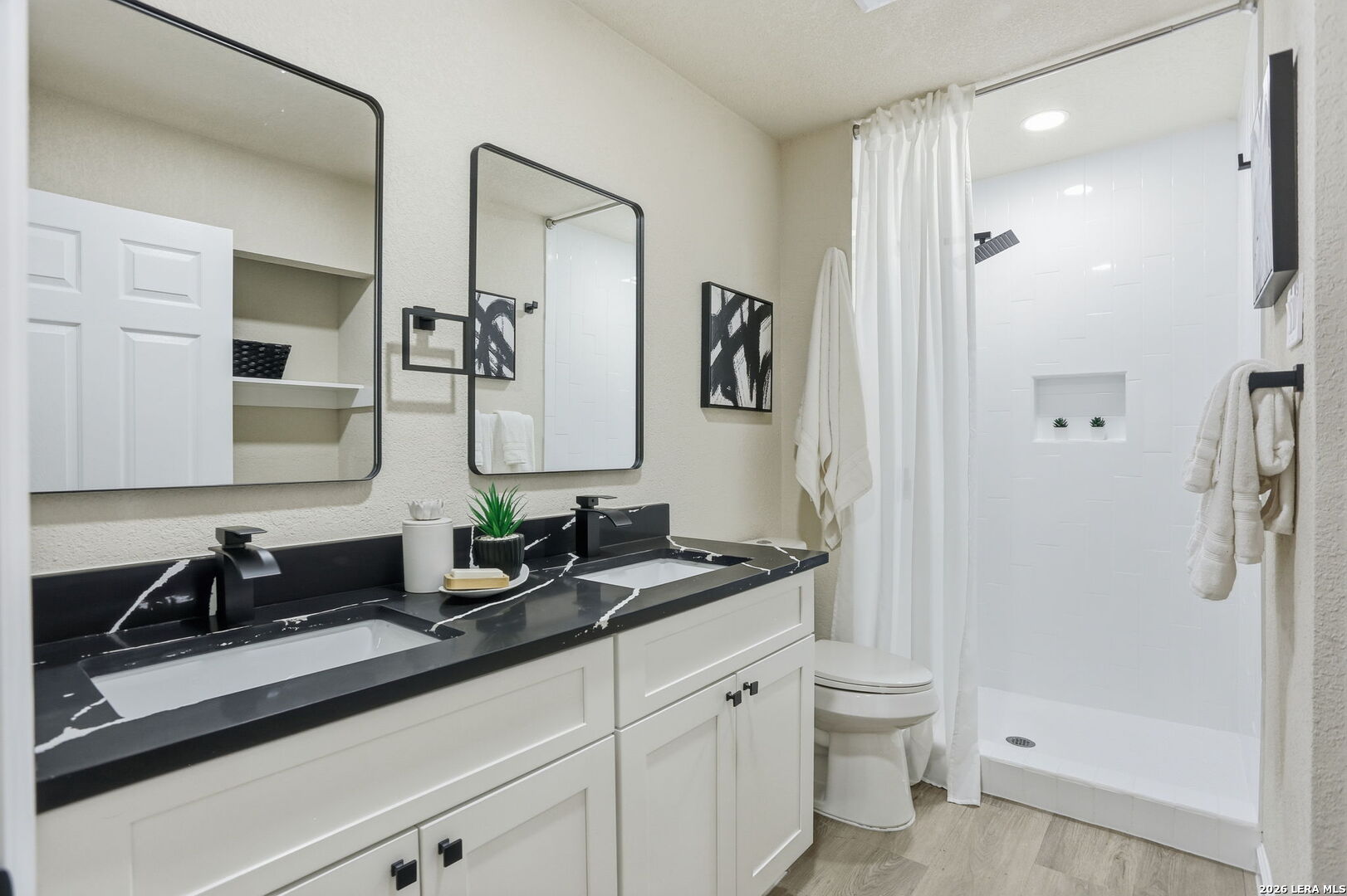 13403 Centerbrook Universal City, TX 78148 - Photo 19 of 30 a bathroom with a double vanity sink toilet mirror and shower