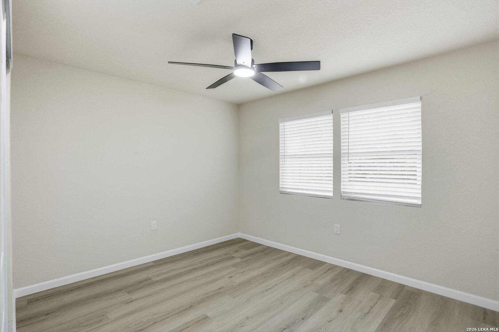13403 Centerbrook Universal City, TX 78148 - Photo 23 of 30 an empty room with wooden floor ceiling fan and windows