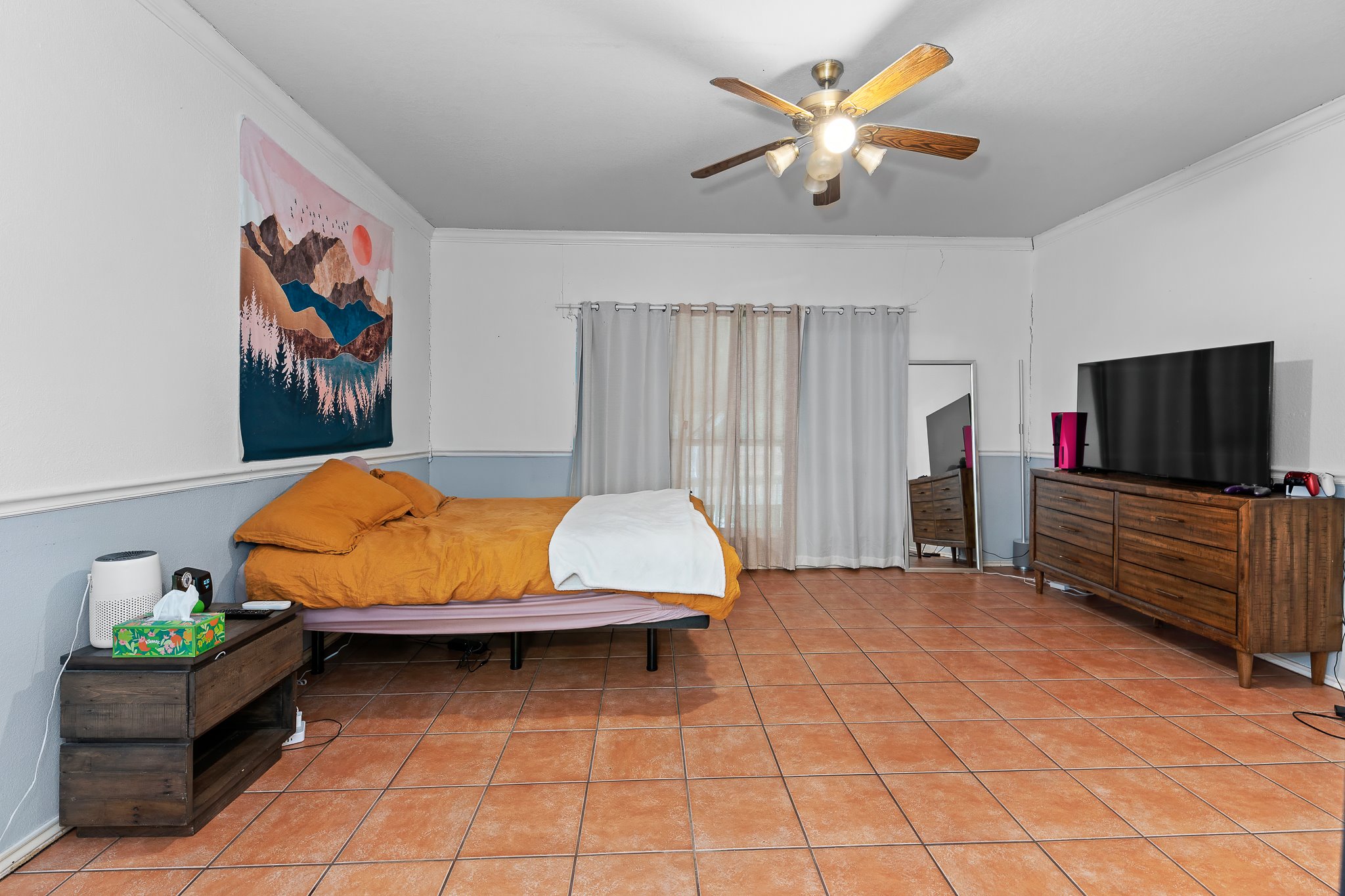 11737 Rydalwater Lane Austin, TX 78754 - Photo 18 of 40 Spacious room featuring durable tile flooring, a functional ceiling fan with integrated lighting, and a window with curtain rods