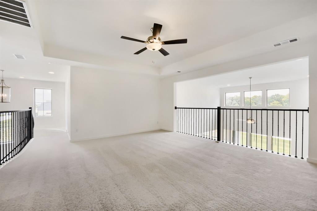 11465 Wulstone Road Fort Worth, TX 76052 - Photo 4 of 27 Spacious loft area featuring light gray carpeting and a tray ceiling