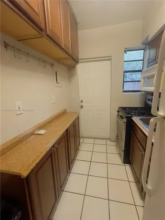 a kitchen with a sink a stove top oven and cabinets