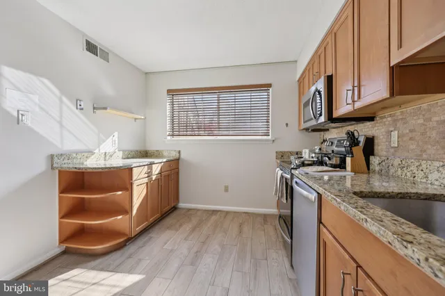 a kitchen with stainless steel appliances granite countertop a sink stove and cabinets