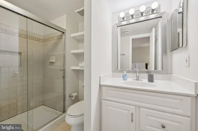 a bathroom with a double vanity sink mirror and toilet