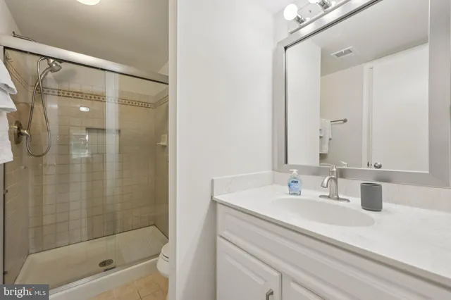 a bathroom with a shower sink vanity and mirror