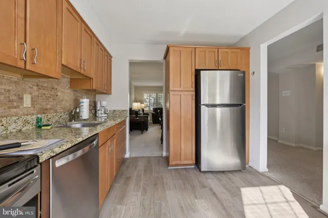 a kitchen with a refrigerator a microwave a sink and cabinets