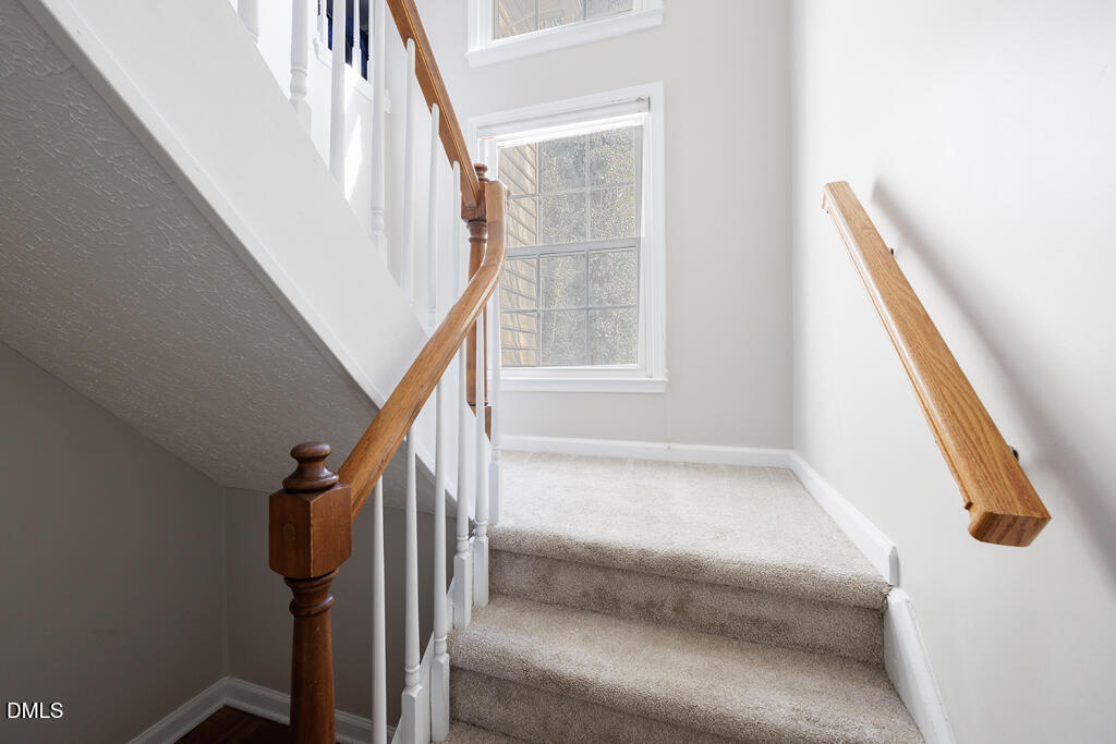 412 Oak Hollow Court Raleigh, NC 27613 - Photo 7 of 24 a view of staircase with wooden floor and white walls