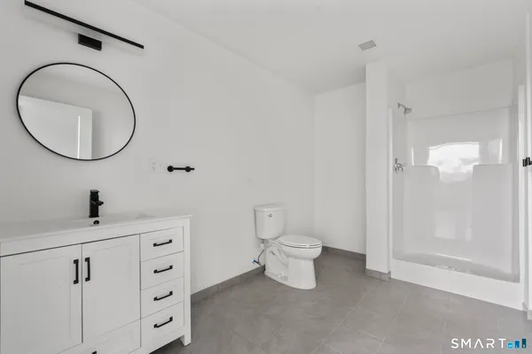 a bathroom with a sink a toilet and a mirror