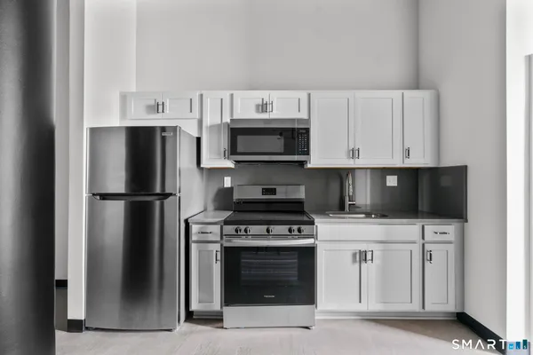 a kitchen with stainless steel appliances a stove a microwave and a refrigerator