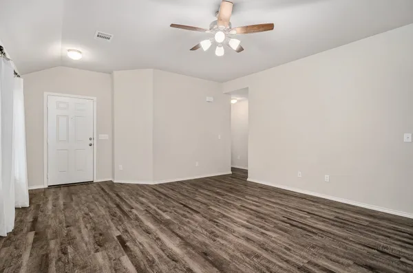 wooden floor in an empty room with a fan
