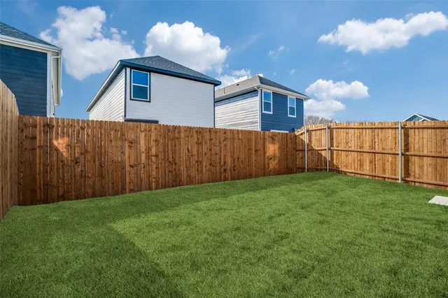 a view of backyard with potted plants and wooden fence