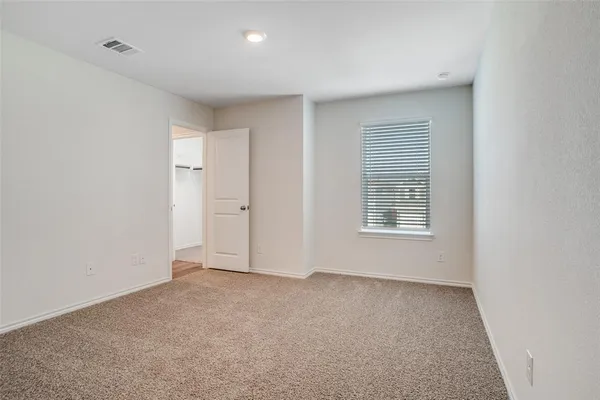 an empty room with wooden floor and window