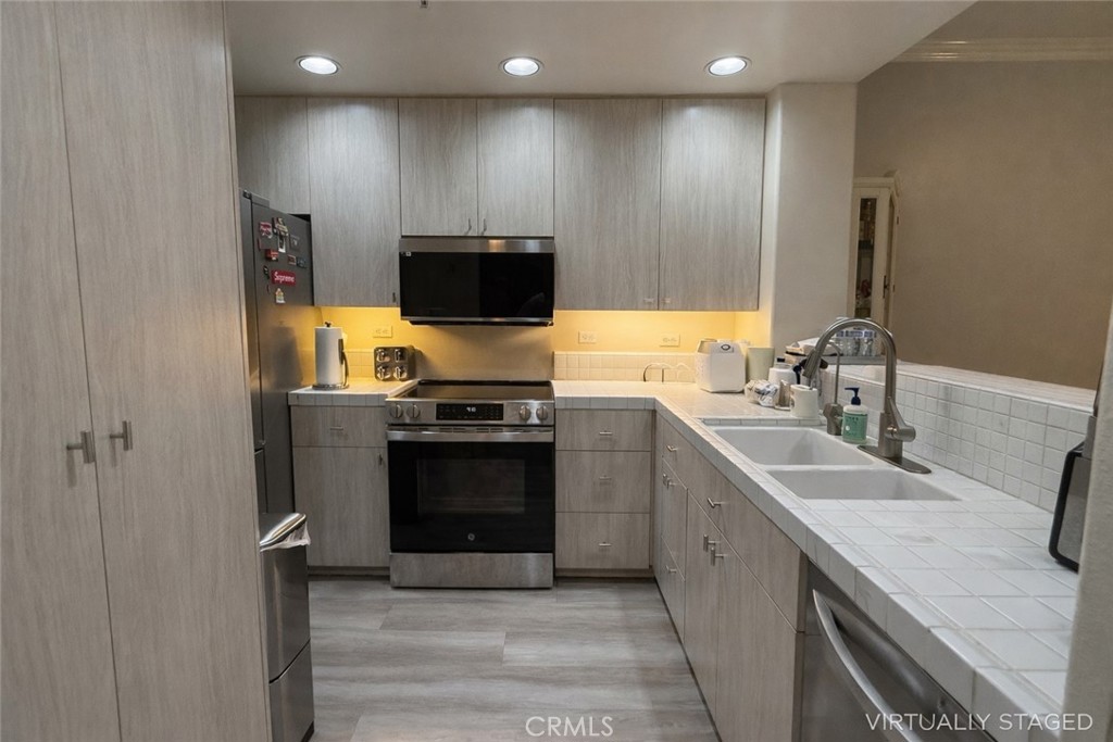 2253 Martin, Unit 107 Irvine, CA 92612 - Photo 3 of 17 a kitchen with stainless steel appliances a stove sink and microwave