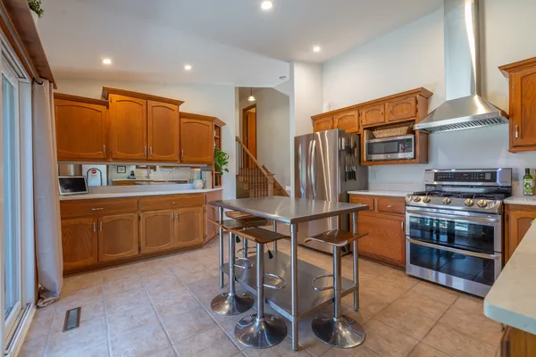 a kitchen with stainless steel appliances a stove a sink a microwave a refrigerator and cabinets