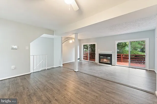 an empty room with wooden floor and fireplace