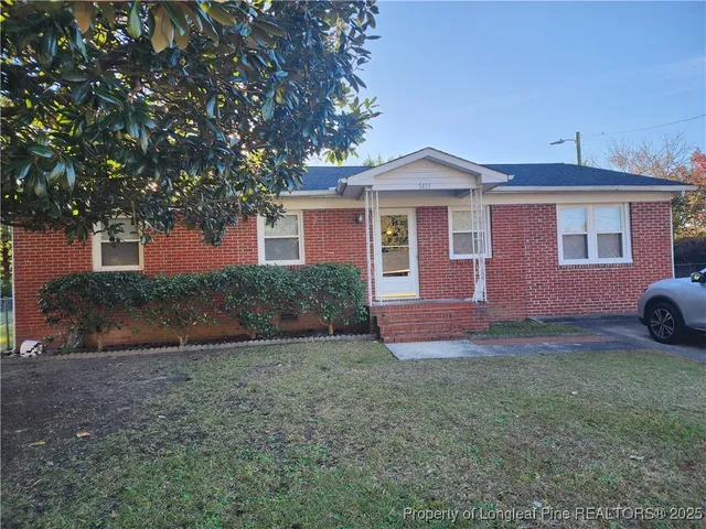 a front view of a house with a garden and yard