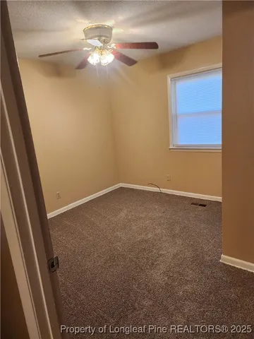 an empty room with a window and a fan