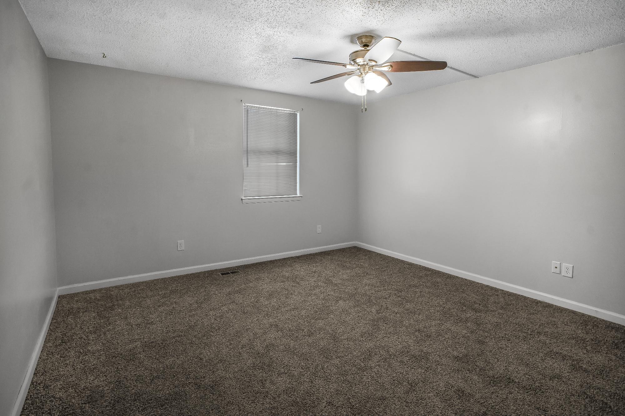 1301 Neelys Bend Road, Unit 73 Madison, TN 37115 - Photo 13 of 17 an empty room with a chandelier fan and windows