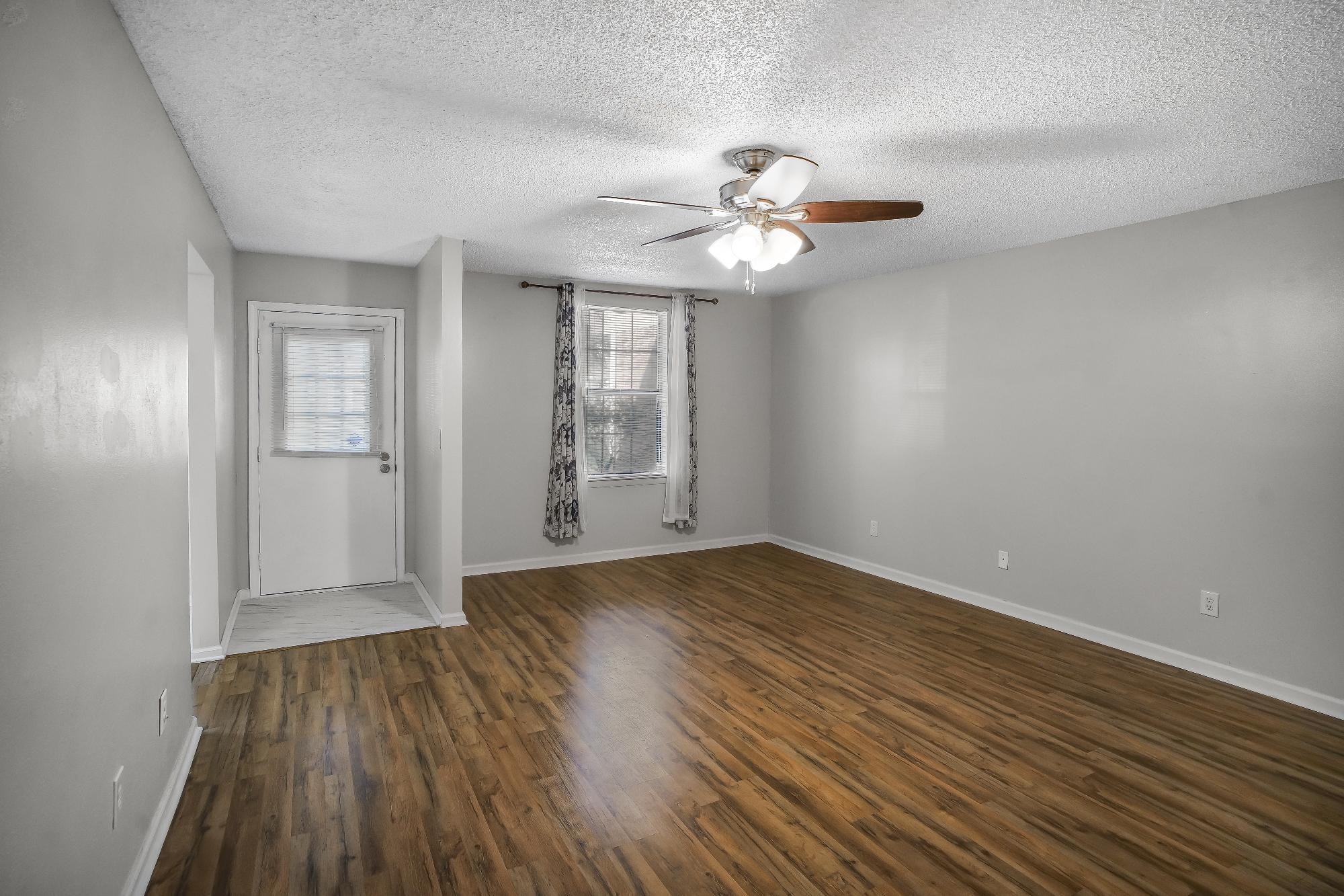 1301 Neelys Bend Road, Unit 73 Madison, TN 37115 - Photo 3 of 17 an empty room with wooden floor chandelier fan and windows