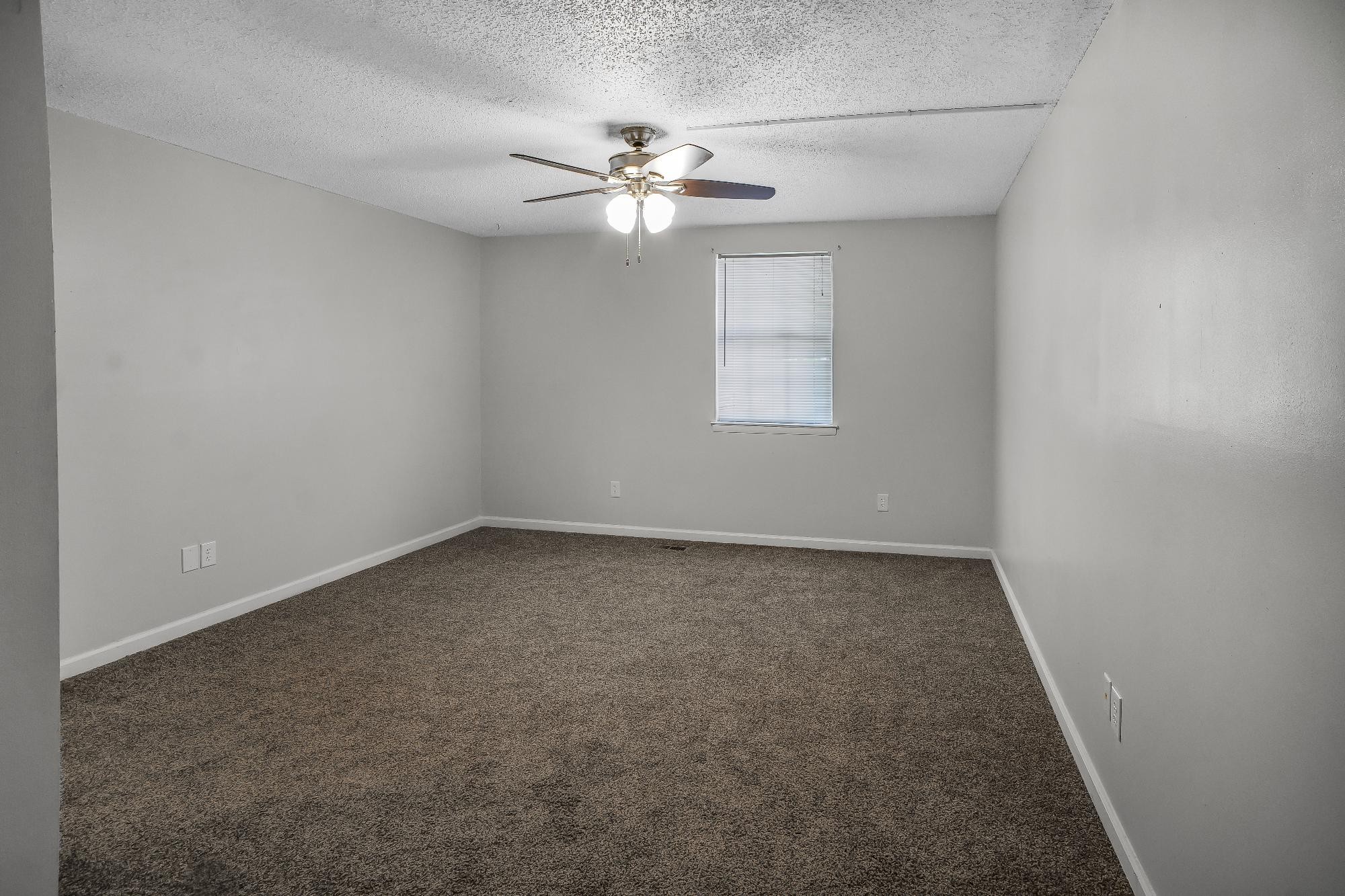 1301 Neelys Bend Road, Unit 73 Madison, TN 37115 - Photo 10 of 17 an empty room with a chandelier fan and windows