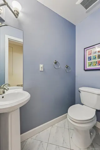 a bathroom with a sink a toilet and mirror