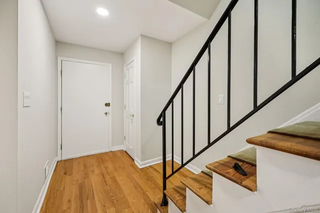 a view of a hallway with wooden floor and staircase