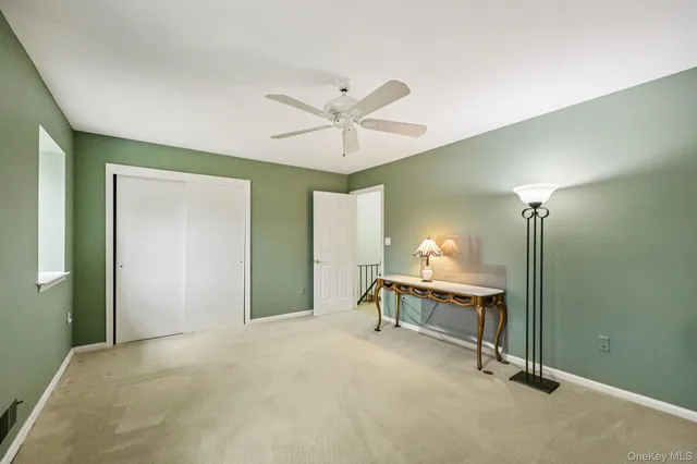 a view of a room with a chandelier fan and a window