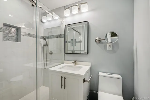 a bathroom with a sink a toilet and mirror