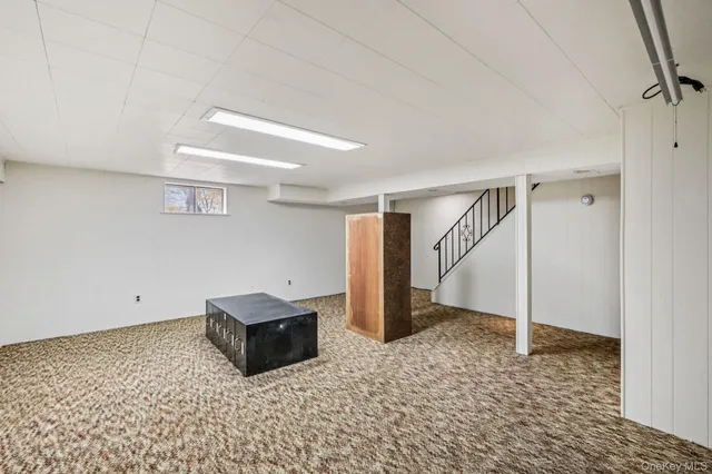 a living room with a refrigerator and cabinets
