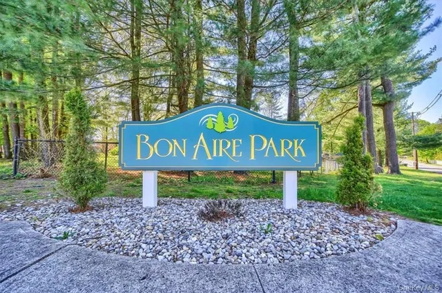 a blue sign that is sitting in front of a tree