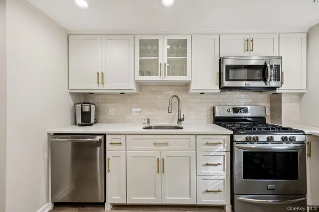 a kitchen with white cabinets and appliances