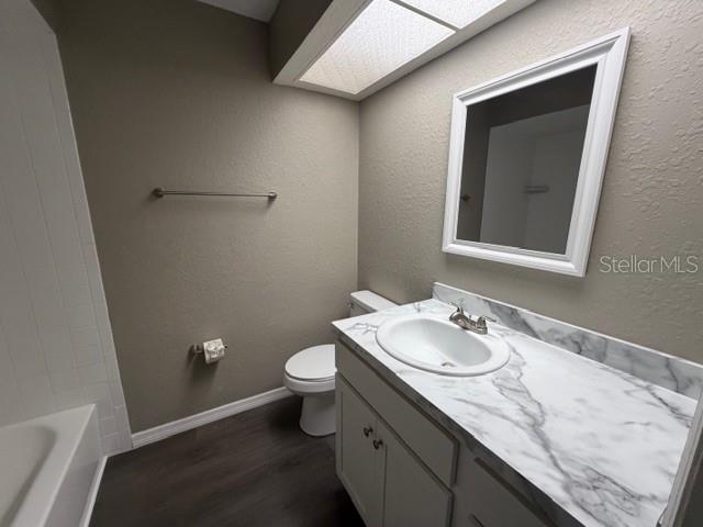 4400 Millwood Road, Unit E Spring Hill, FL 34608 - Photo 13 of 21 a bathroom with a granite countertop sink toilet and mirror