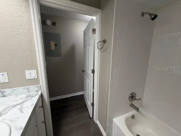 a bathroom with a granite countertop tub sink and mirror