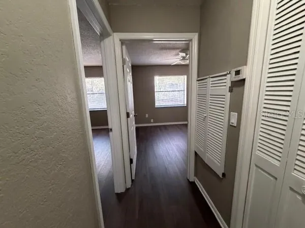 a view of a hallway with wooden floor and staircase