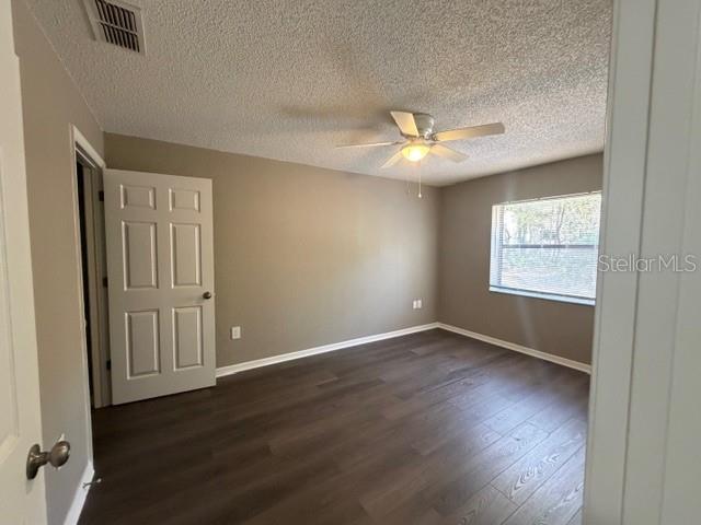 4400 Millwood Road, Unit E Spring Hill, FL 34608 - Photo 18 of 21 an empty room with wooden floor chandelier fan and windows