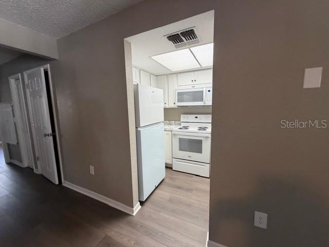 4400 Millwood Road, Unit E Spring Hill, FL 34608 - Photo 8 of 21 a kitchen with stainless steel appliances a refrigerator and wooden floor