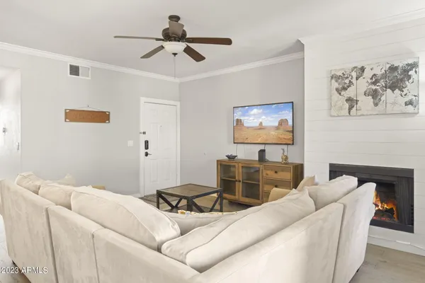 a living room with furniture and a ceiling fan
