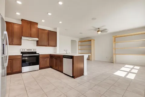 a kitchen with stainless steel appliances granite countertop a refrigerator and a stove top oven