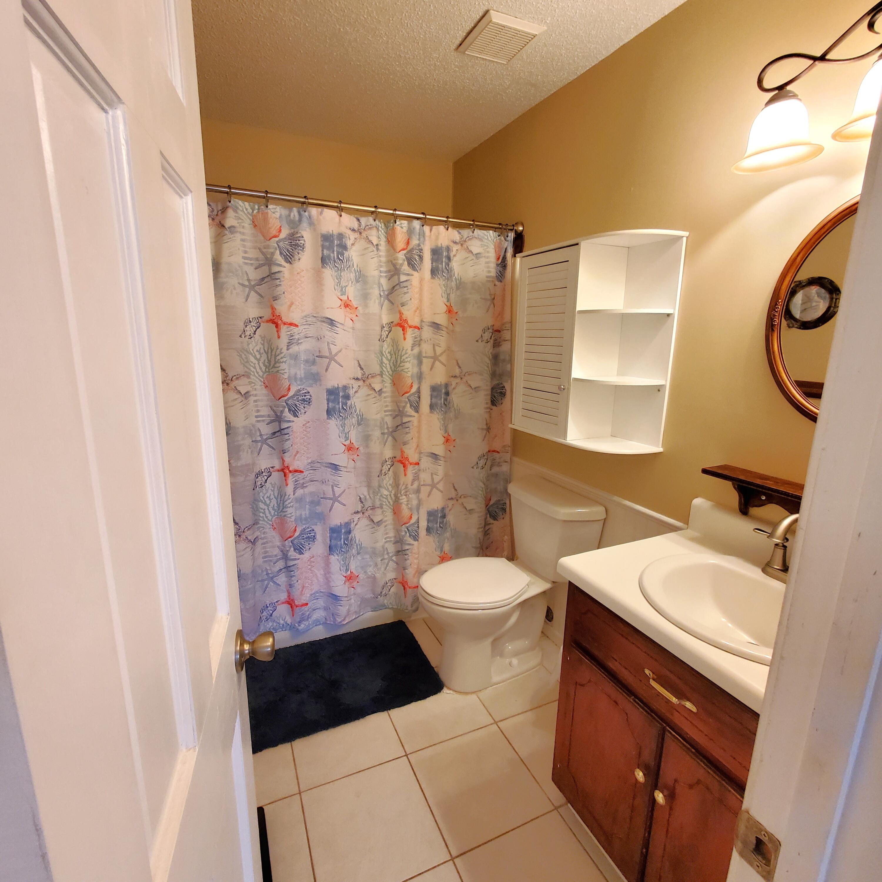 6060 Old Bethel Road Crestview, FL 32536 - Photo 14 of 25 a bathroom with a sink a toilet a shower curtain and a mirror