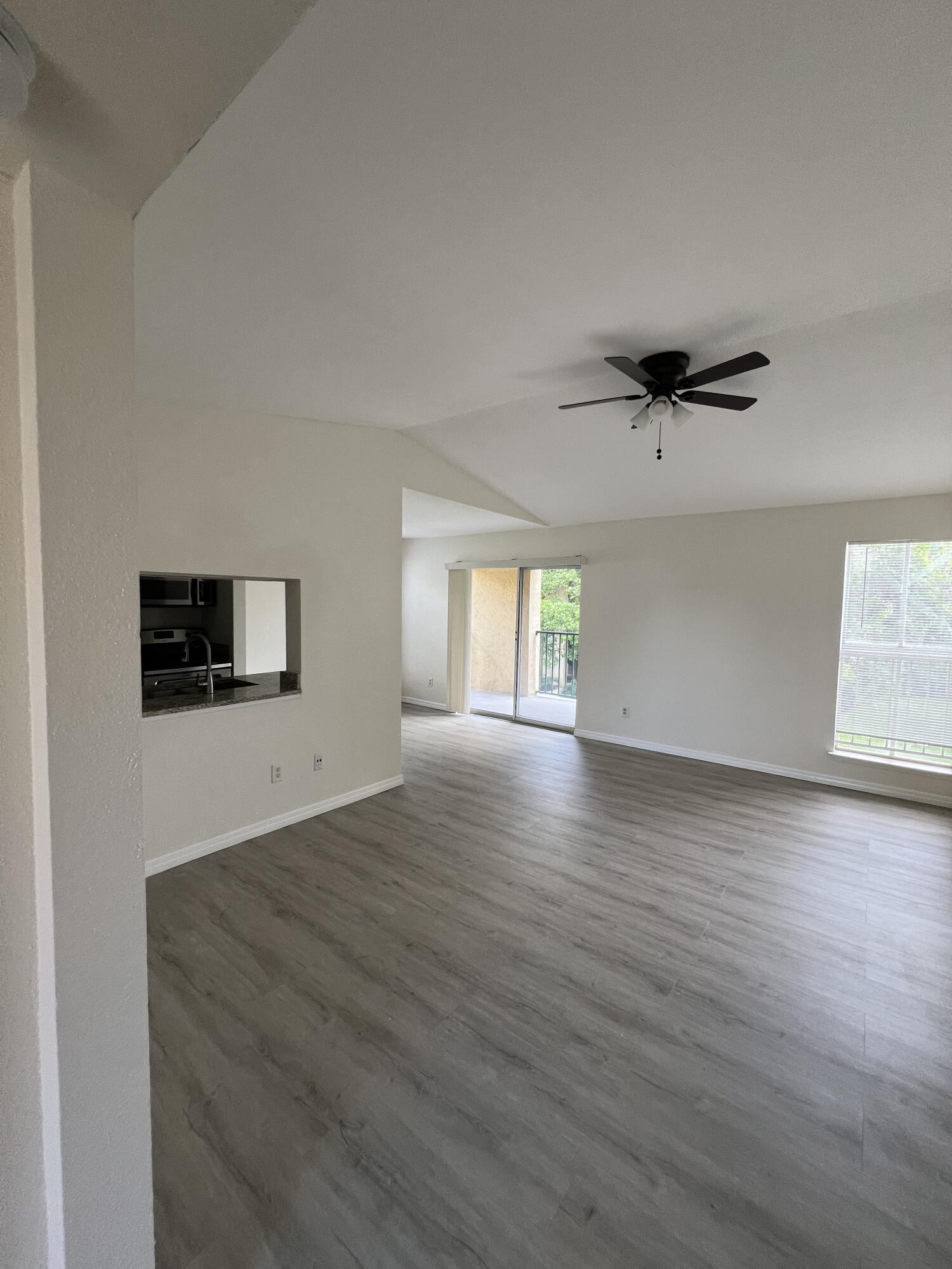 899 Riverside Drive, Unit 620 Coral Springs, FL 33071 - Photo 5 of 46 an empty room with wooden floor cabinet and windows