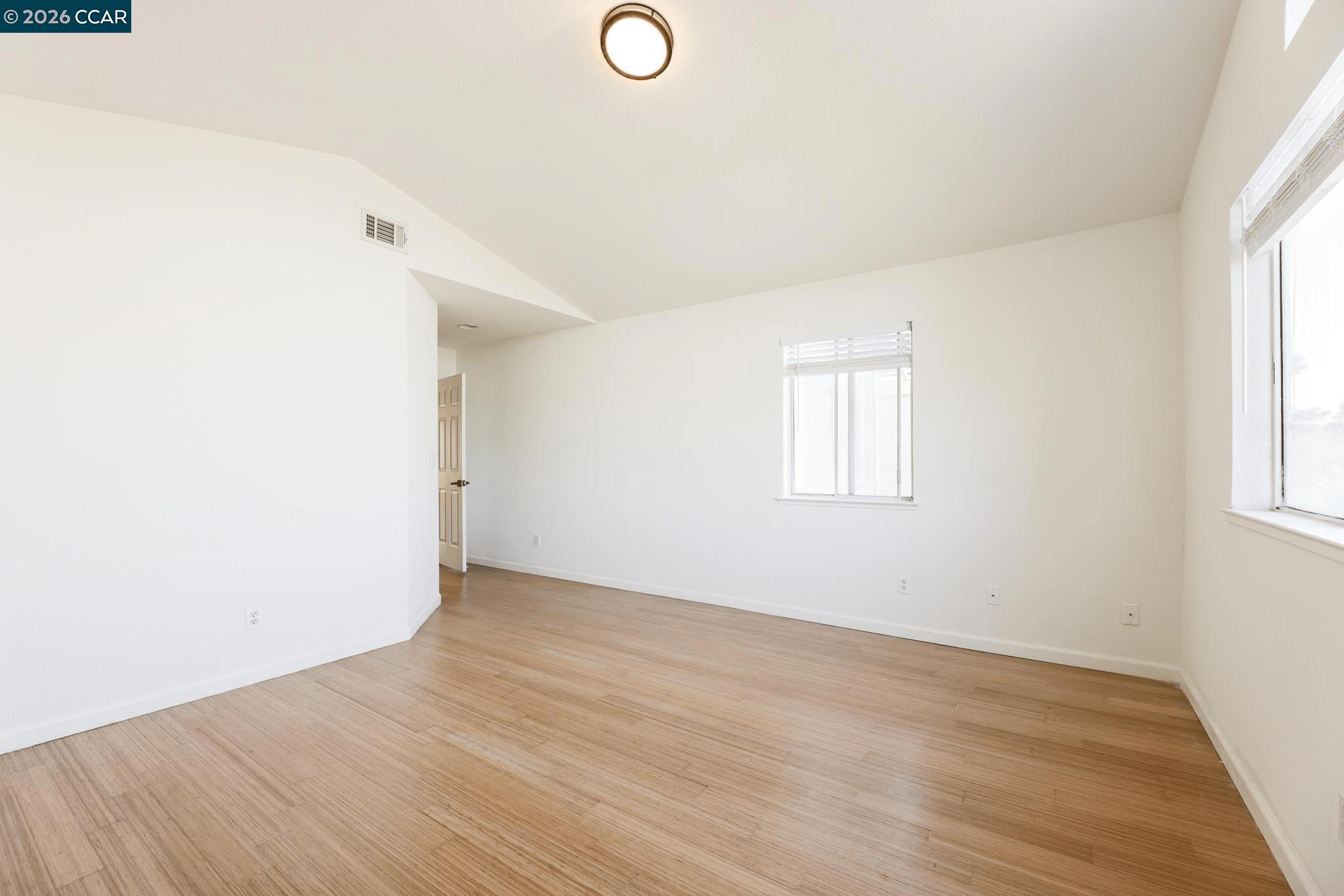 528 Dohrmann Lane Pinole, CA 94564 - Photo 21 of 27 an empty room with wooden floor and windows