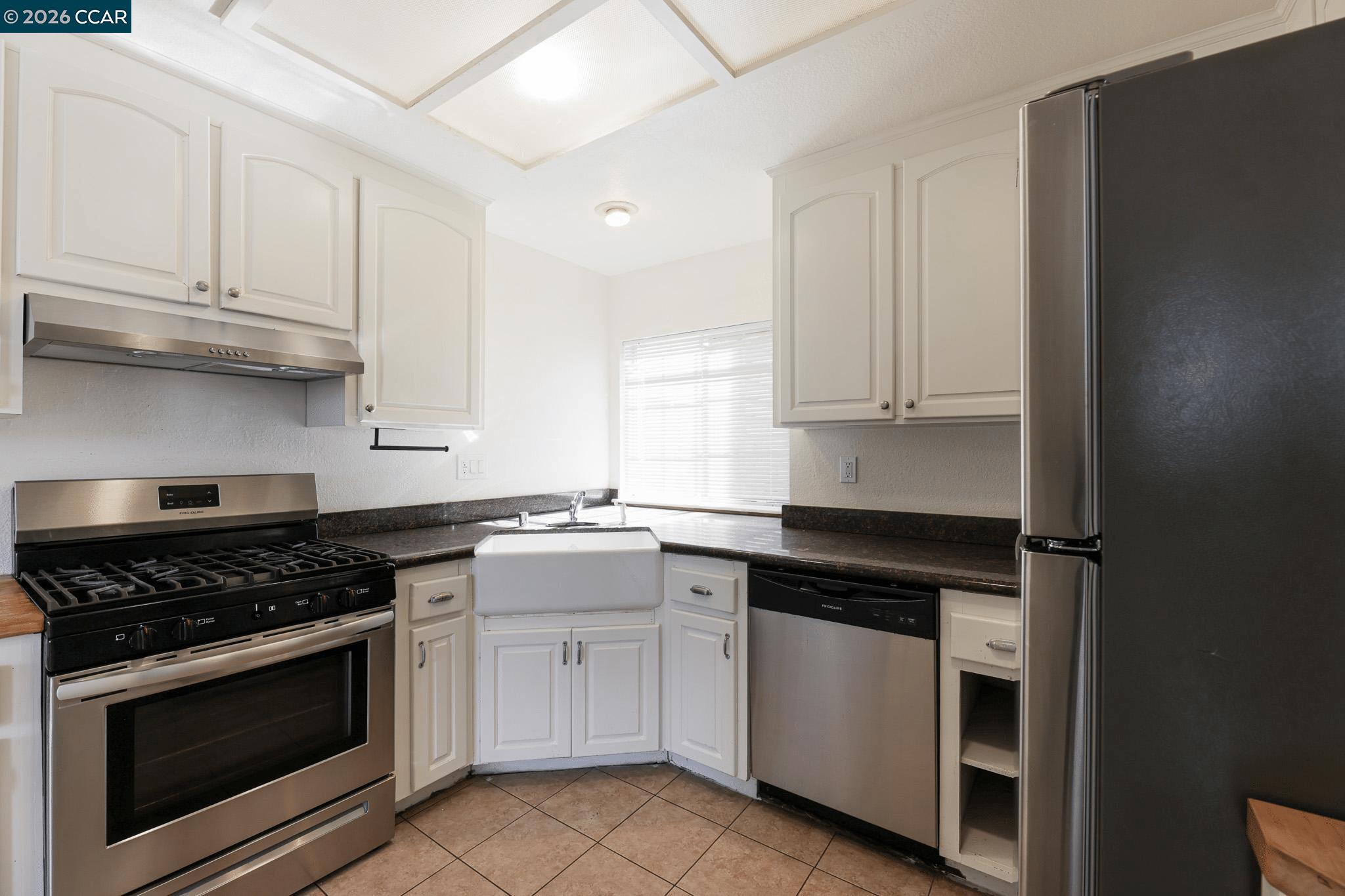 528 Dohrmann Lane Pinole, CA 94564 - Photo 6 of 27 a kitchen with white cabinets and appliances