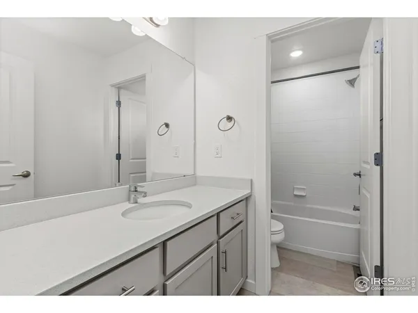 a bathroom with a sink toilet double vanity and shower