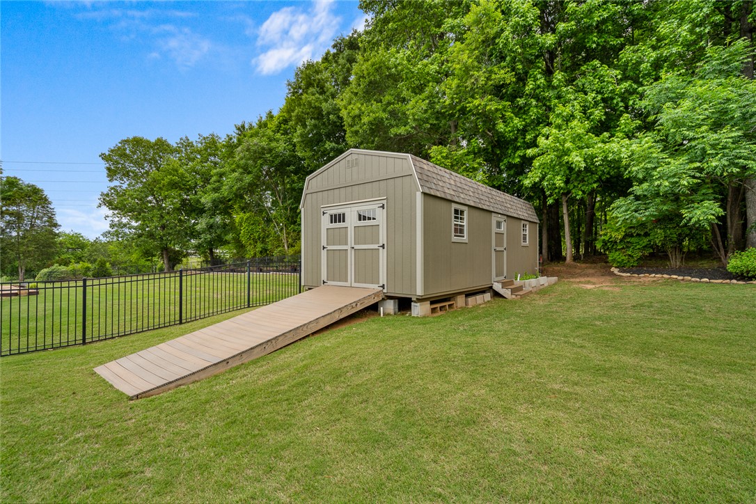 128 Baybrooke Lane Anderson, SC 29621 - Photo 36 of 37 A versatile storage shed with a wide ramp provides practical utility in a verdant backyard setting.