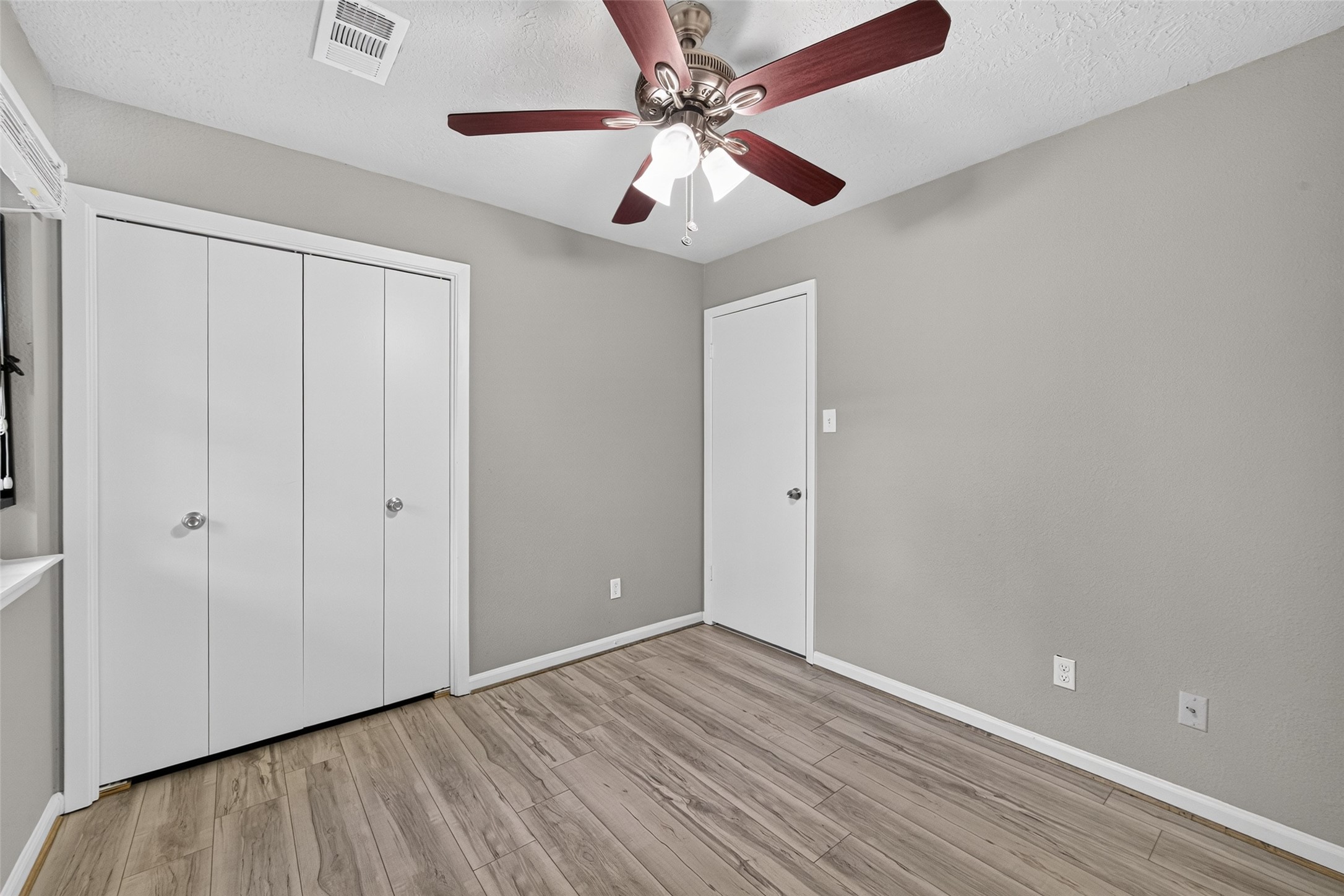 16203 Beck Ridge Drive Houston, TX 77053 - Photo 20 of 29 Bed room featuring sleek laminate flooring, a modern ceiling fan, and ample closet space for organization.