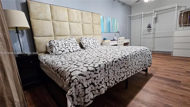 a bedroom with bed and wooden floor