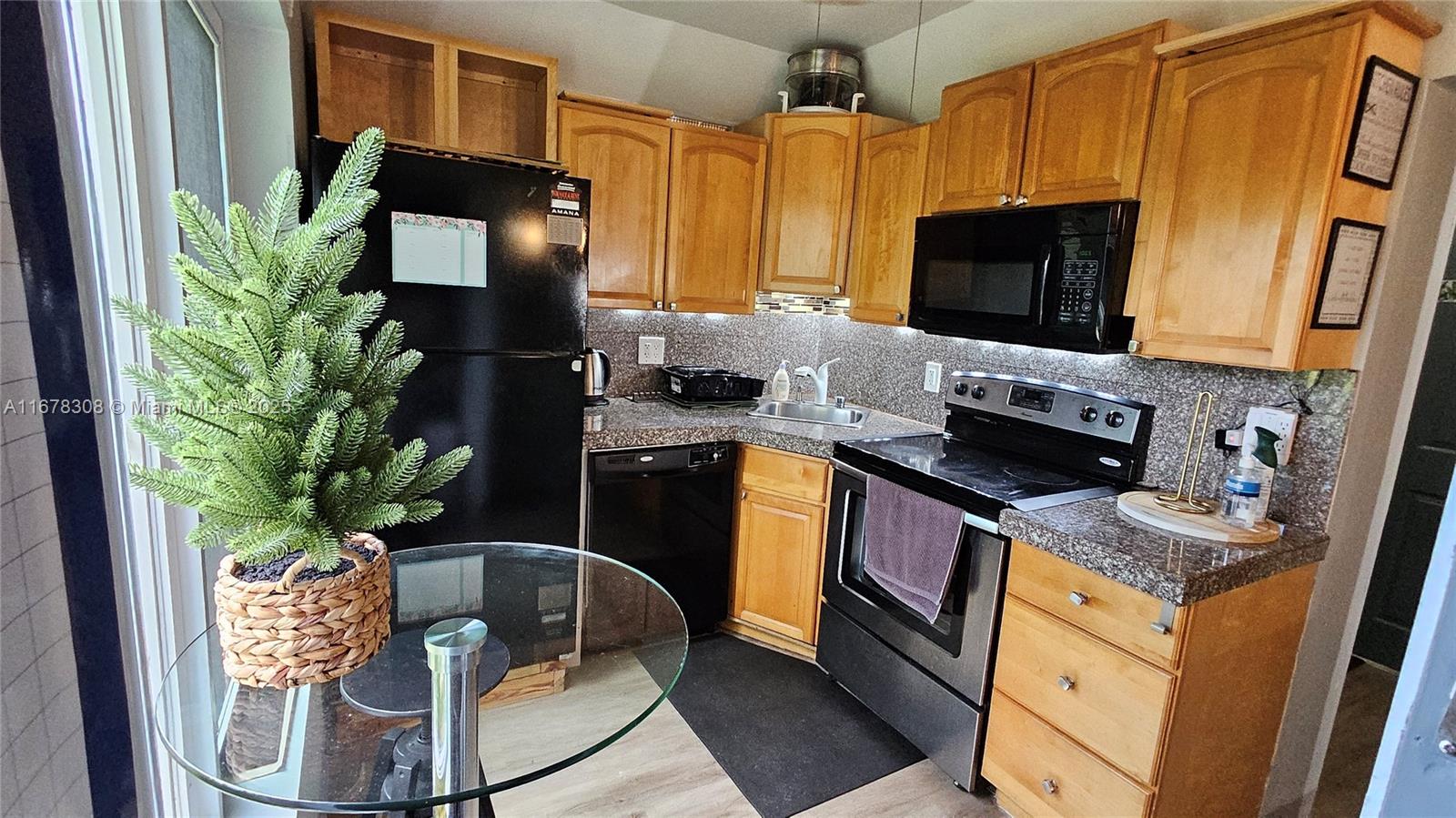 3600 Southwest S Le Jeune Road, Unit 3600 Coral Gables, FL 33134 - Photo 8 of 25 a kitchen with stainless steel appliances granite countertop a stove a sink and a microwave